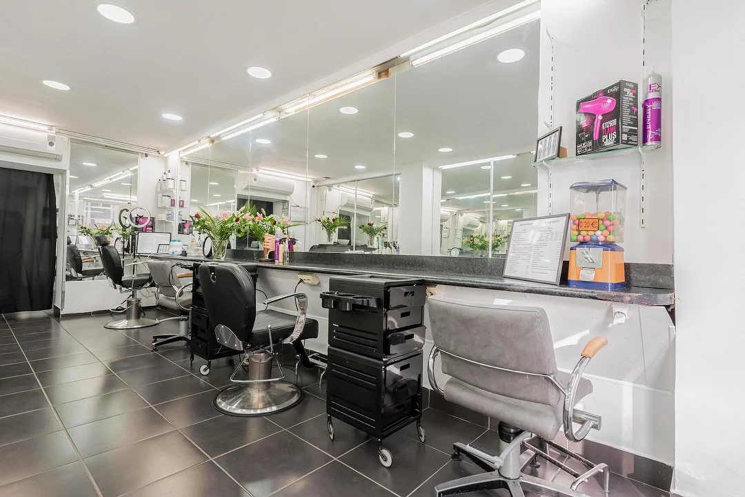 Les postes de coiffure du salon, face aux grands miroirs