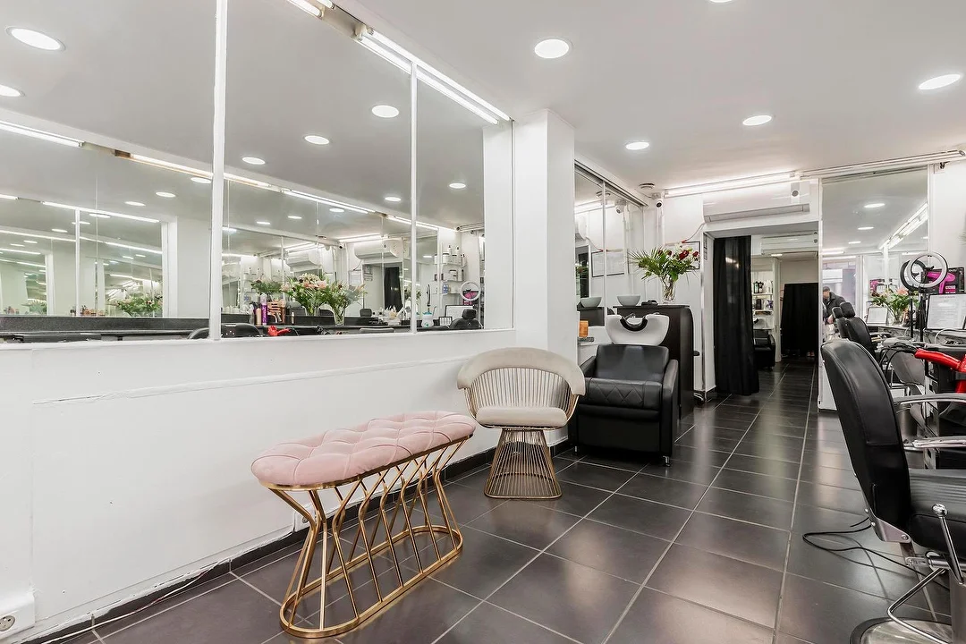 L’espace d’accueil du salon Oasis de Beauté, avec sa banquette rose et ses grands miroirs